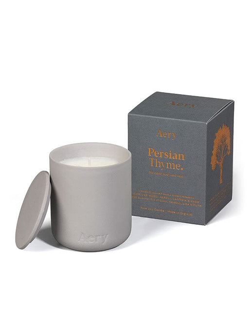 Grey Persian Thyme candle by Aery displayed next to product packaging on white background 