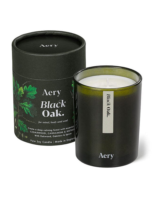 Green Black Oak candle displayed next to product packaging on white background 