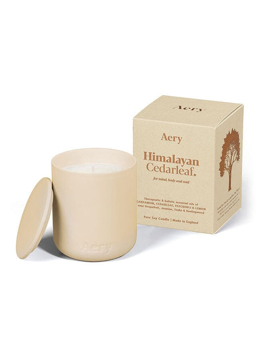 Cream Himalayan Cedarleaf candle by Aery displayed next to product packaging on white background 