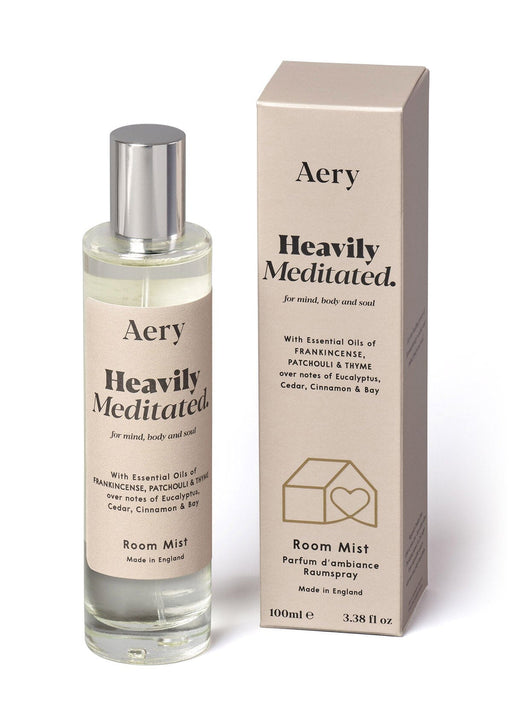 Beige Heavily Meditated Room Mist by Aery displayed next to product packaging on white bacground 