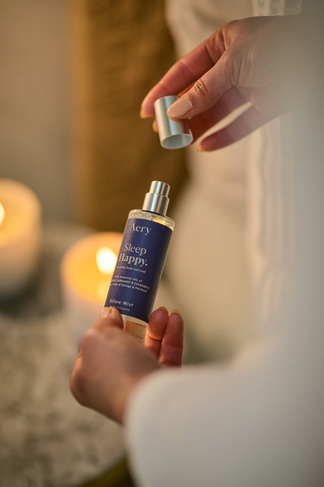 Blue Sleep Happy pillow mist by aery displayed in hands 