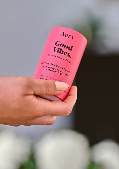 Pink Good Vibes fragrance oil product packaging by Aery displayed next in hand 