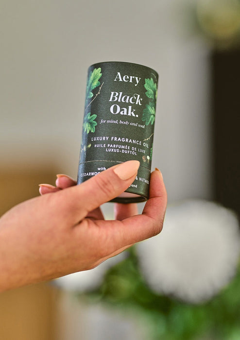 Green Black oak fragrance oil by Aery displayed in hands