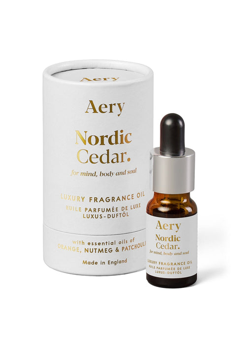 White Nordic Cedar fragrance oil by Aery displayed next to product packaging on white bacground 