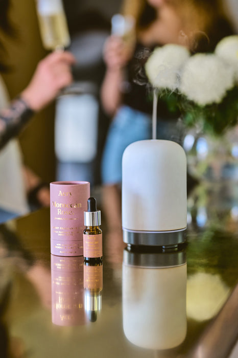 Aubergine Moroccan Rose fragrance oil by Aery displayed next to product packaging and electric diffuser placed on gold kitchen surface 