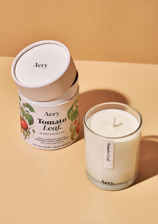 Tomato Leaf candle by Aery displayed next to product packaging on yellow background 