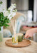 Tomato Leaf diffuser by Aery placed on table with white flowers