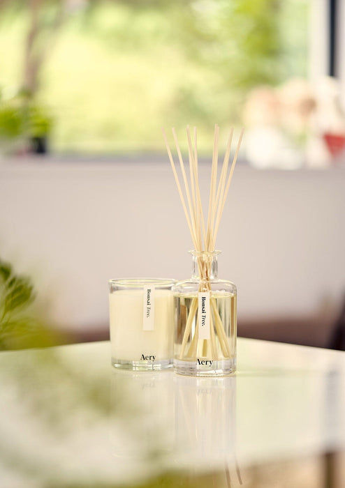 Bonsai Tree diffuser by Aery displayed next to bonsai tree candle placed on white kitchen worktop