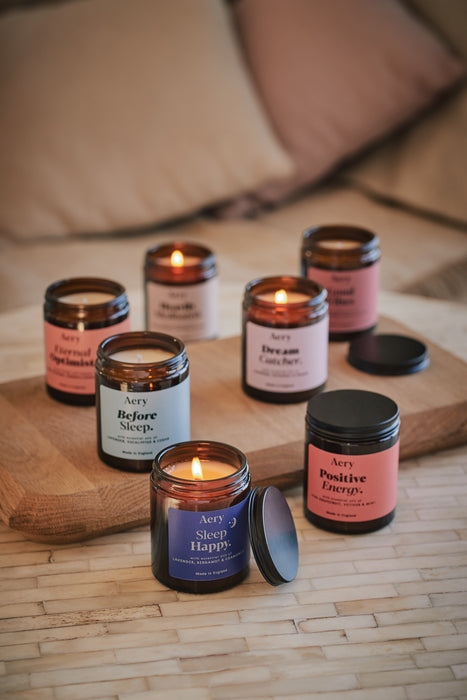 collection of aromatherapy jar candles displayed on wooden tray 