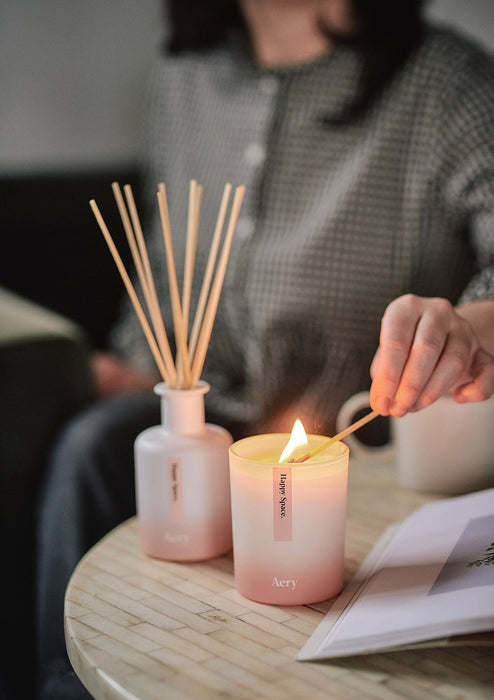 Pink Happy Space candle displayed next to happy space diffuser  placed on circle table