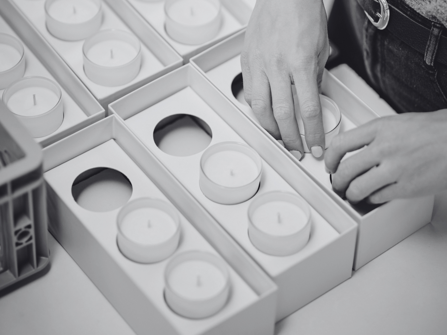 person packing votive candles into gift box packaging