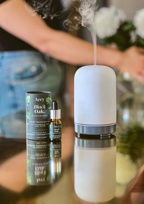 Black Oak fragrance oil displayed next to product packaging by Aery on gold work surface 