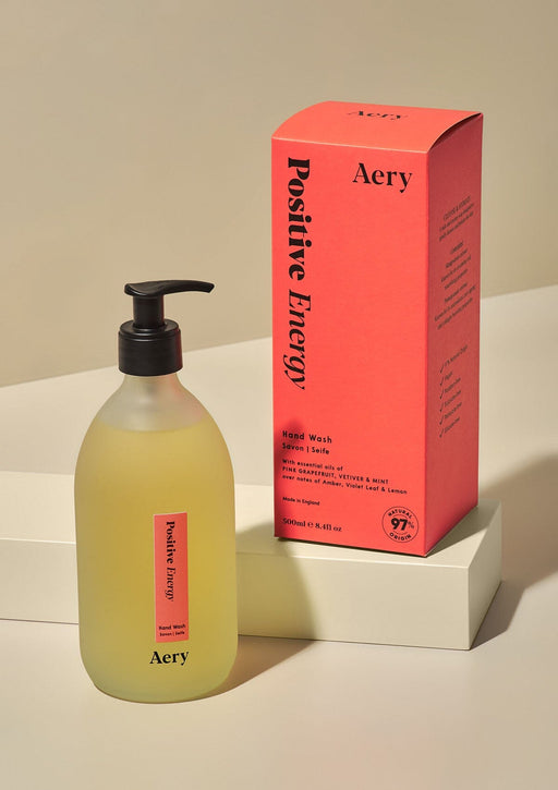 Positive energy hand wash by Aery displayed next to product packaging on cream background 