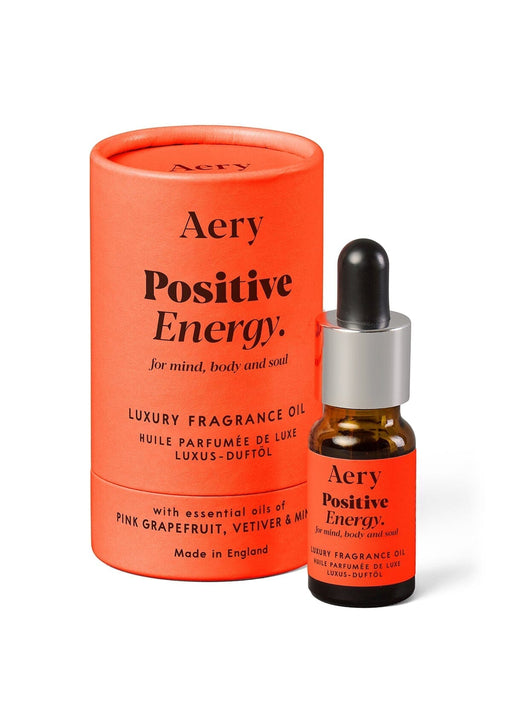 positive energy fragrance oil displayed next to decorative product packaging